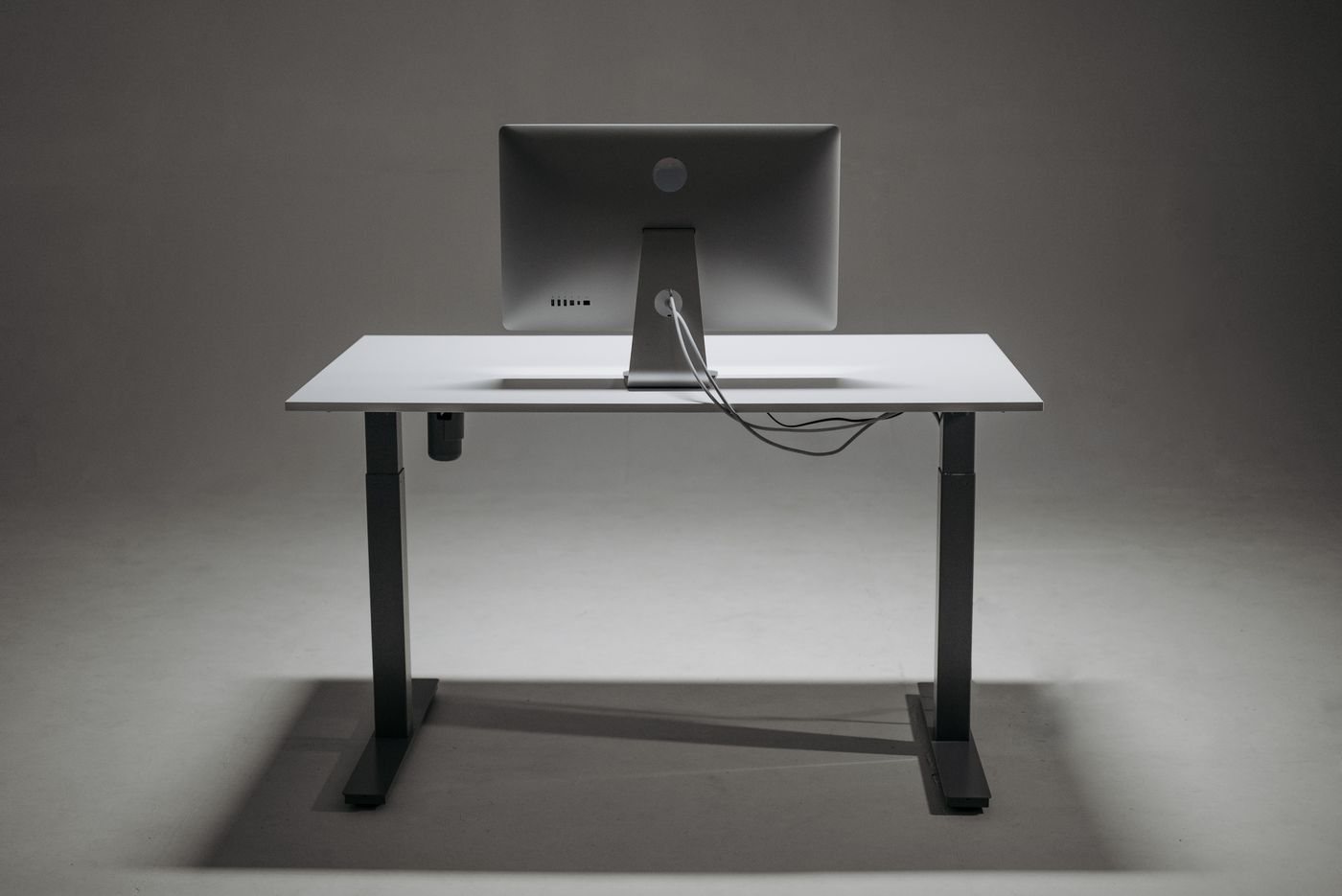 Rear view of an adjustable desk with cables