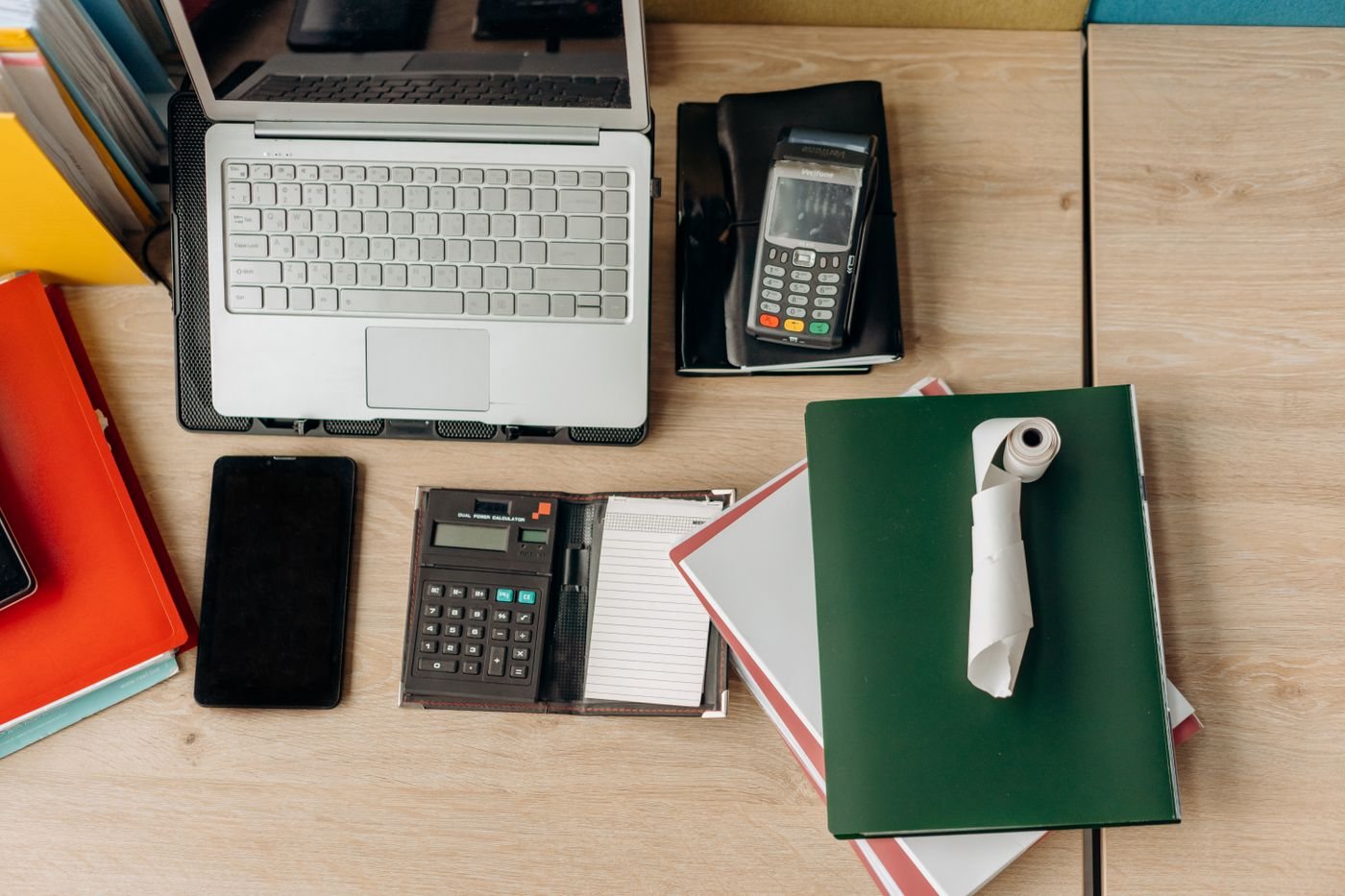 Laptop, calculator, and paperwork arranged on a desk