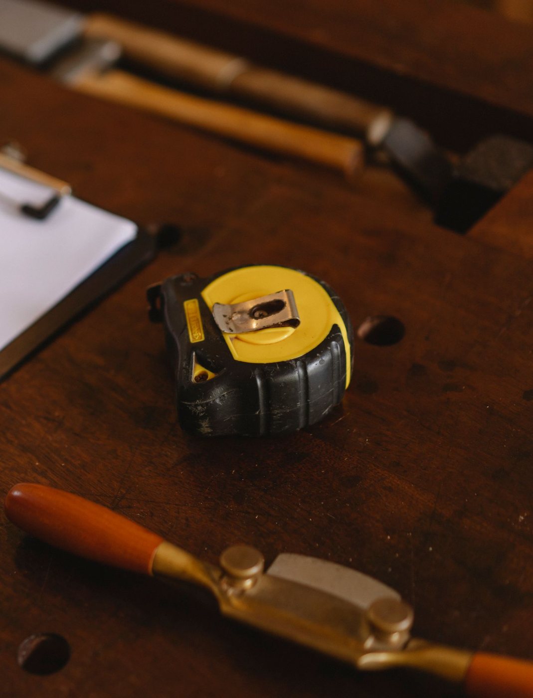 Measuring tape and tools on a wooden work surface