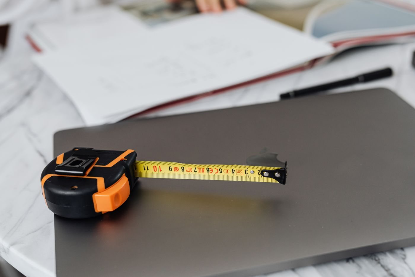 Tape measure beside a laptop on a desk