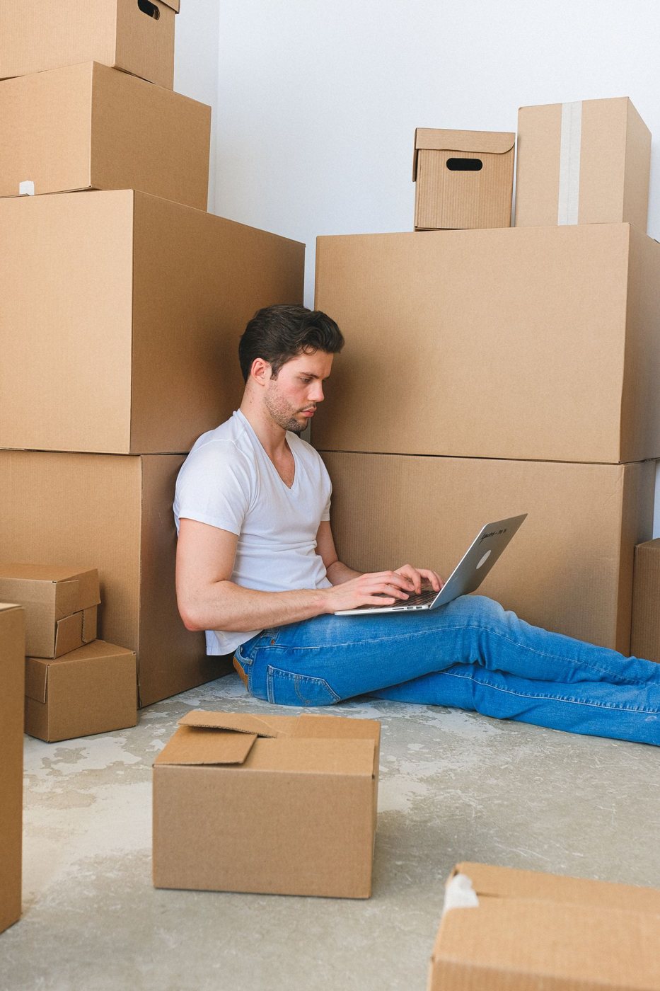 Person using a laptop beside moving boxes