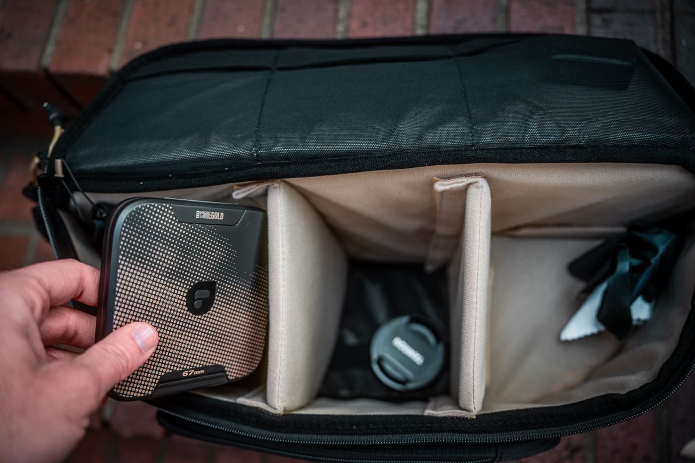 Portable drive being placed in a padded equipment bag