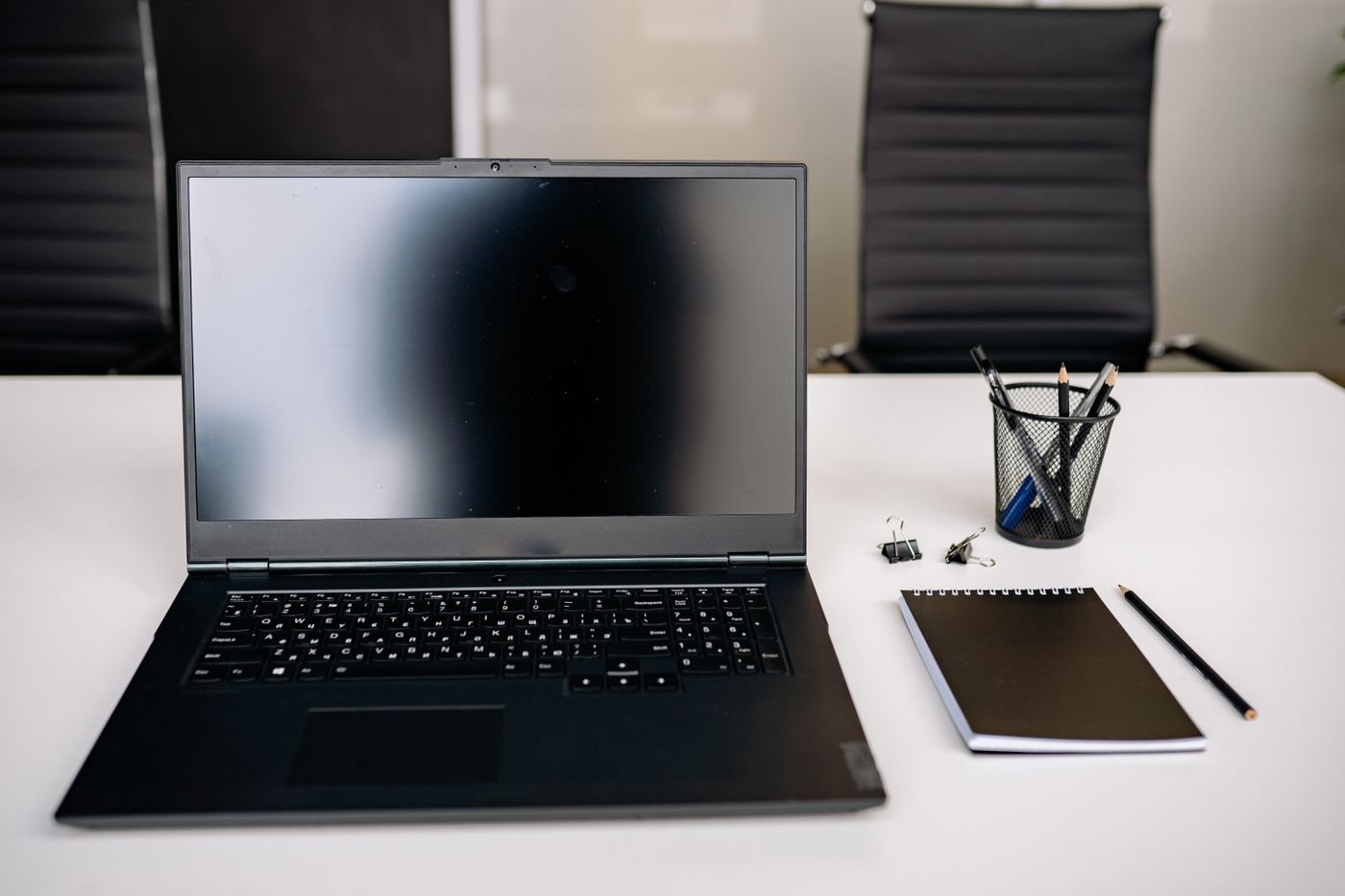 Laptop with notebook and stationery on a desk
