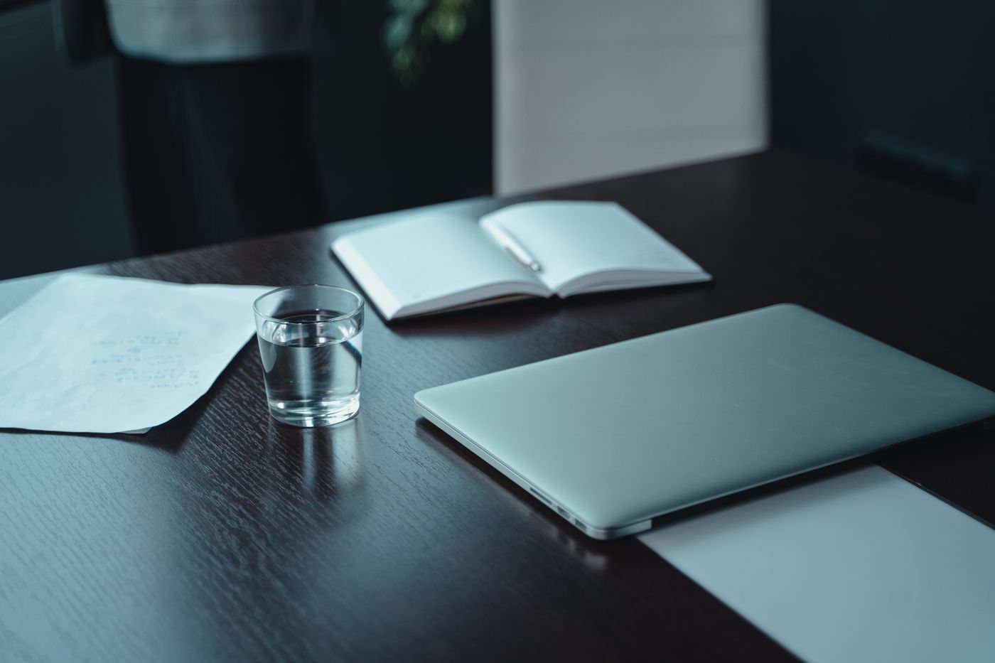 Glass of water beside a laptop on a desk