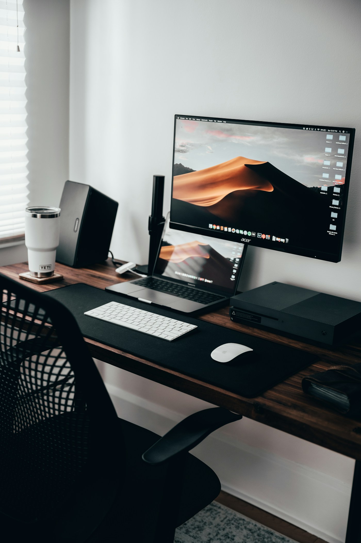Monitor suspended on an arm above a desk