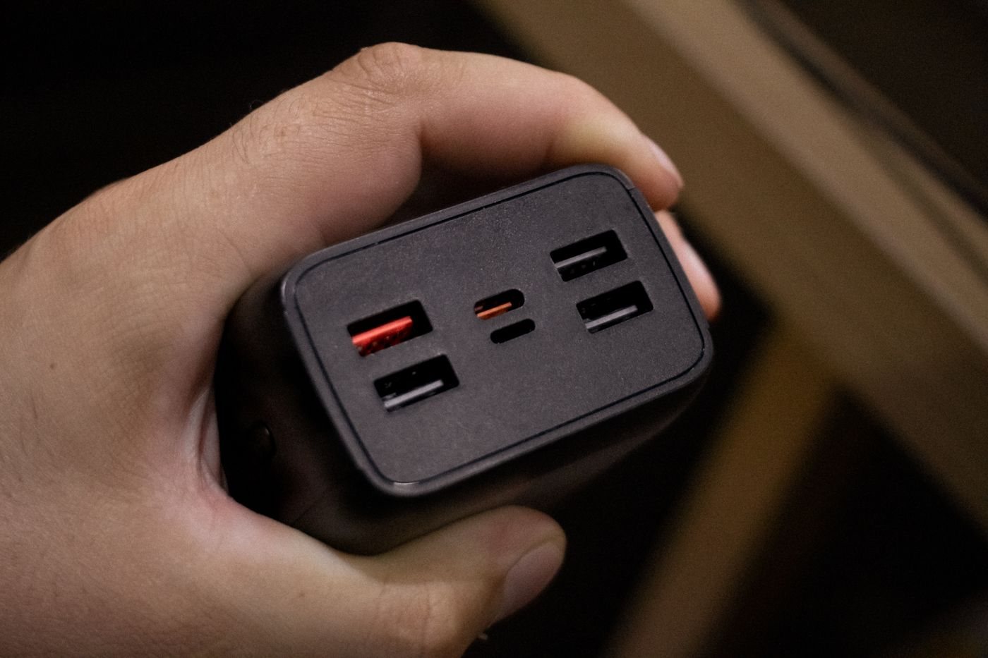 Hand holding a charger with multiple USB ports