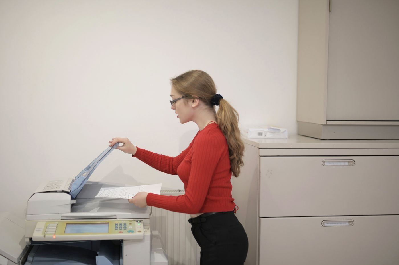Person placing documents in an office scanner