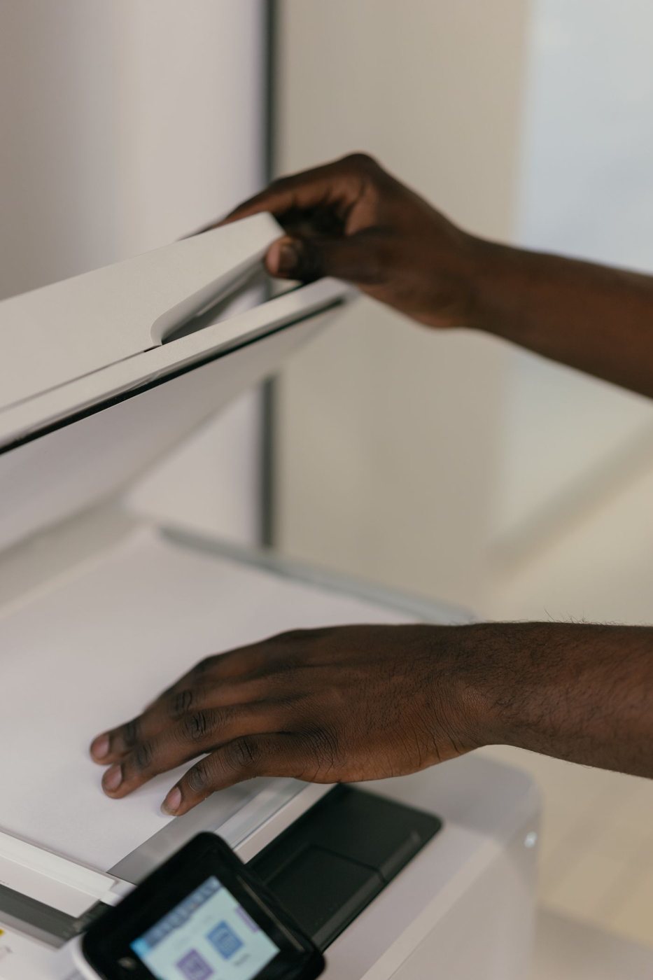 Hands positioning a document on a flatbed scanner
