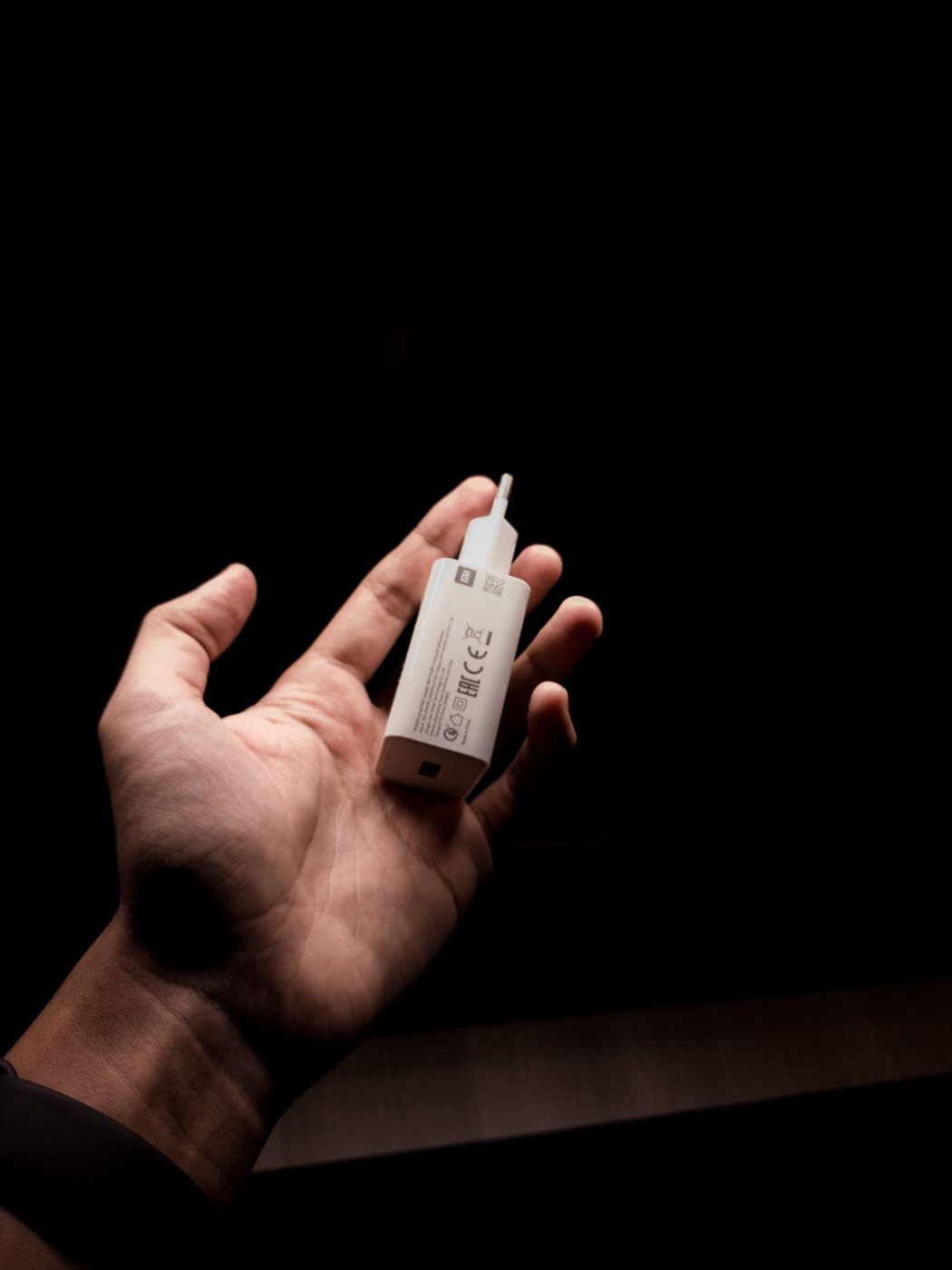 Compact USB wall charger held in a hand