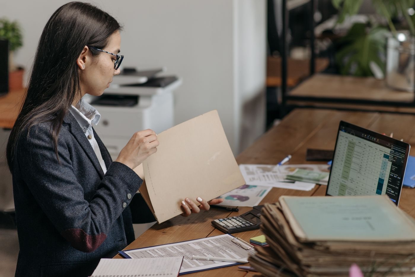 Person reviewing documents beside a laptop