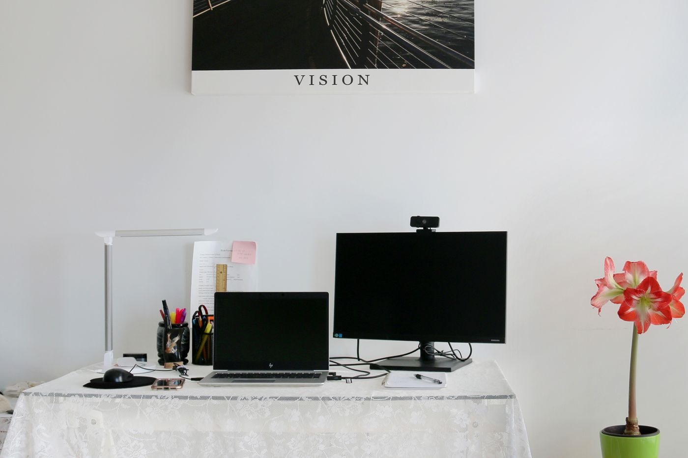 Home workspace with webcam, monitor, and laptop