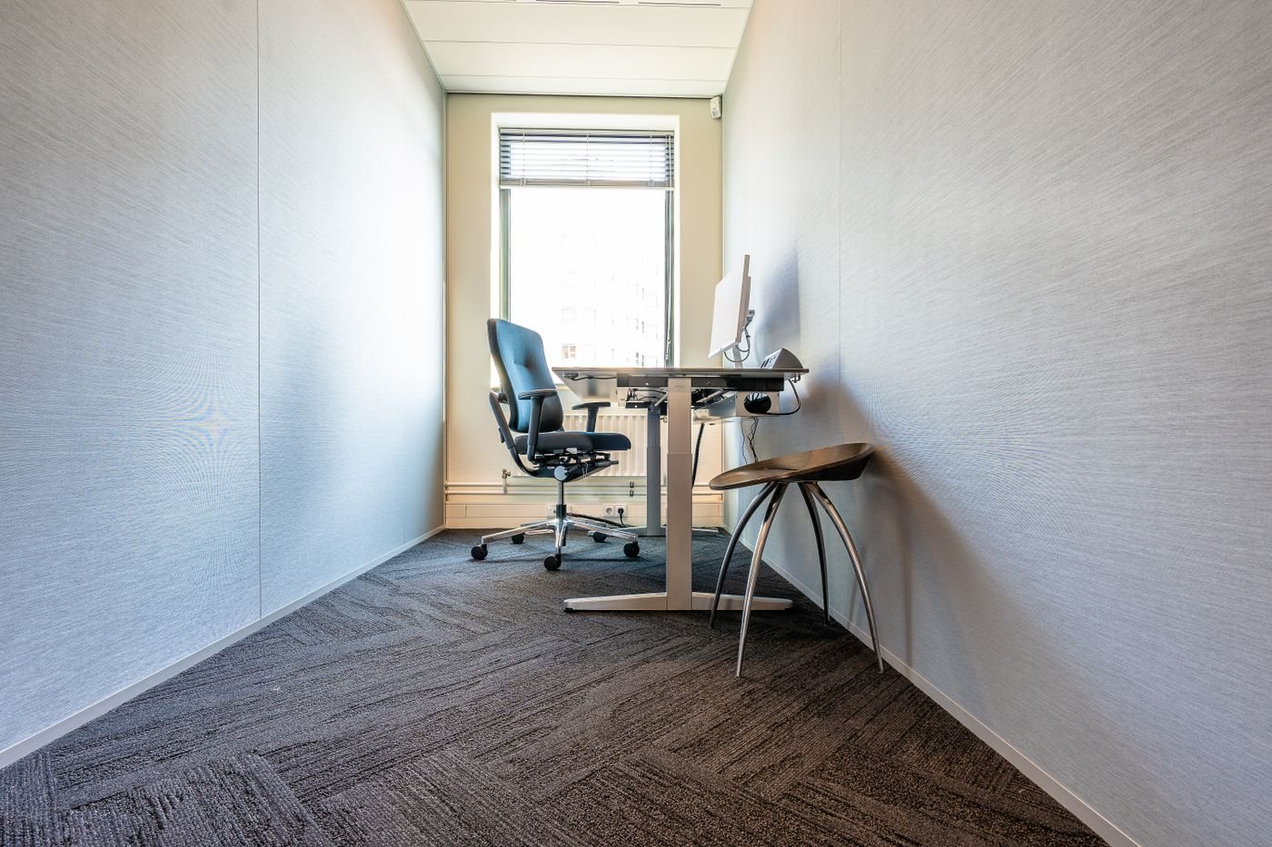 Computer desk and chair beside a large window